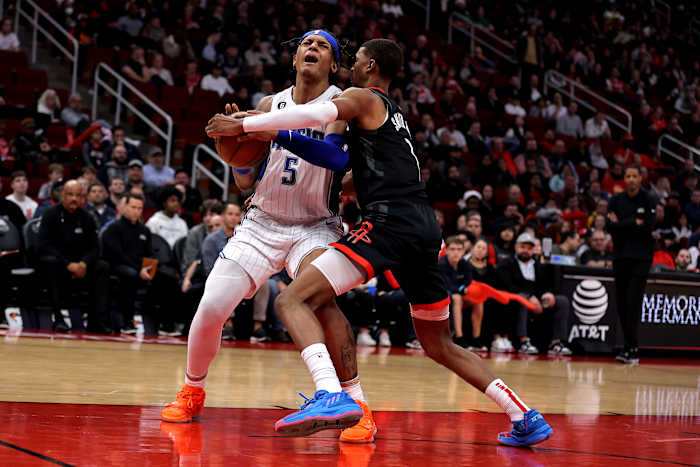 Orlando Magic forward Paolo Banchero (5) wrestles for the ball with Houston Rockets forward Jabari Smith Jr. (1)